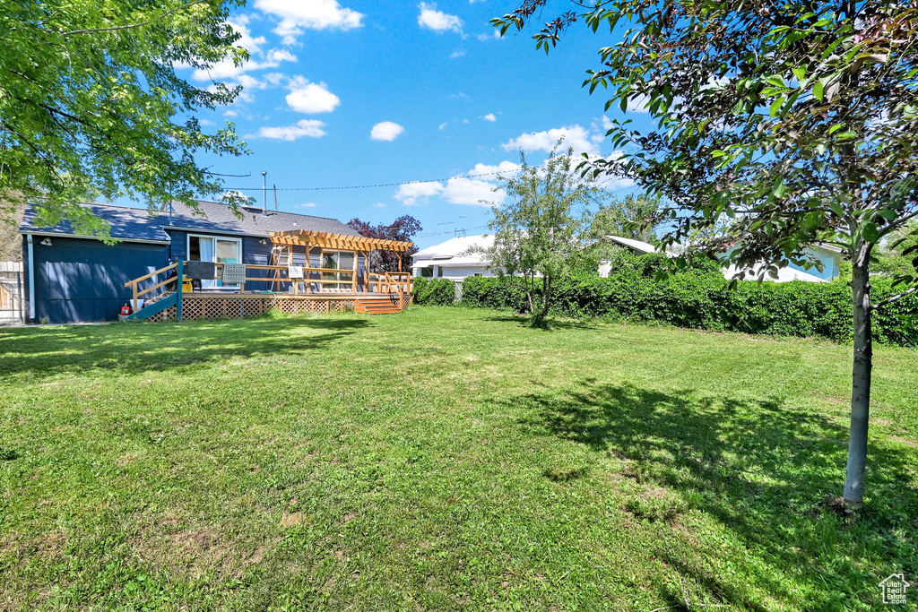 View of green lawn with a wooden deck