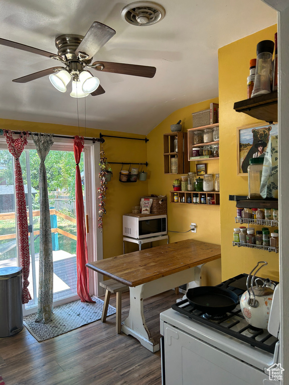 Dining space featuring vaulted ceiling, wood finished floors, and ceiling fan