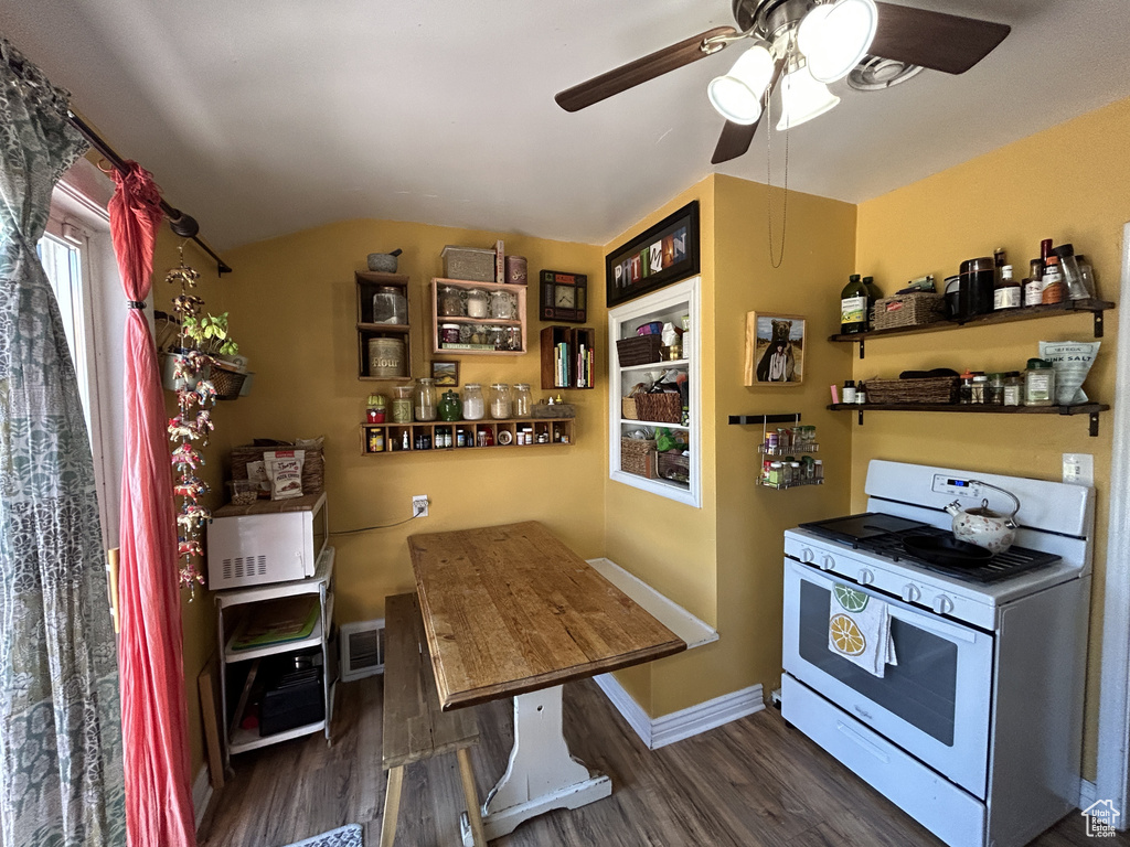 Kitchen with white gas range oven, wood finished floors, ceiling fan, and lofted ceiling