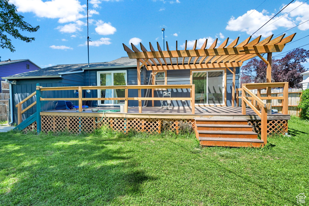 Back of house featuring a lawn, a pergola, and a deck