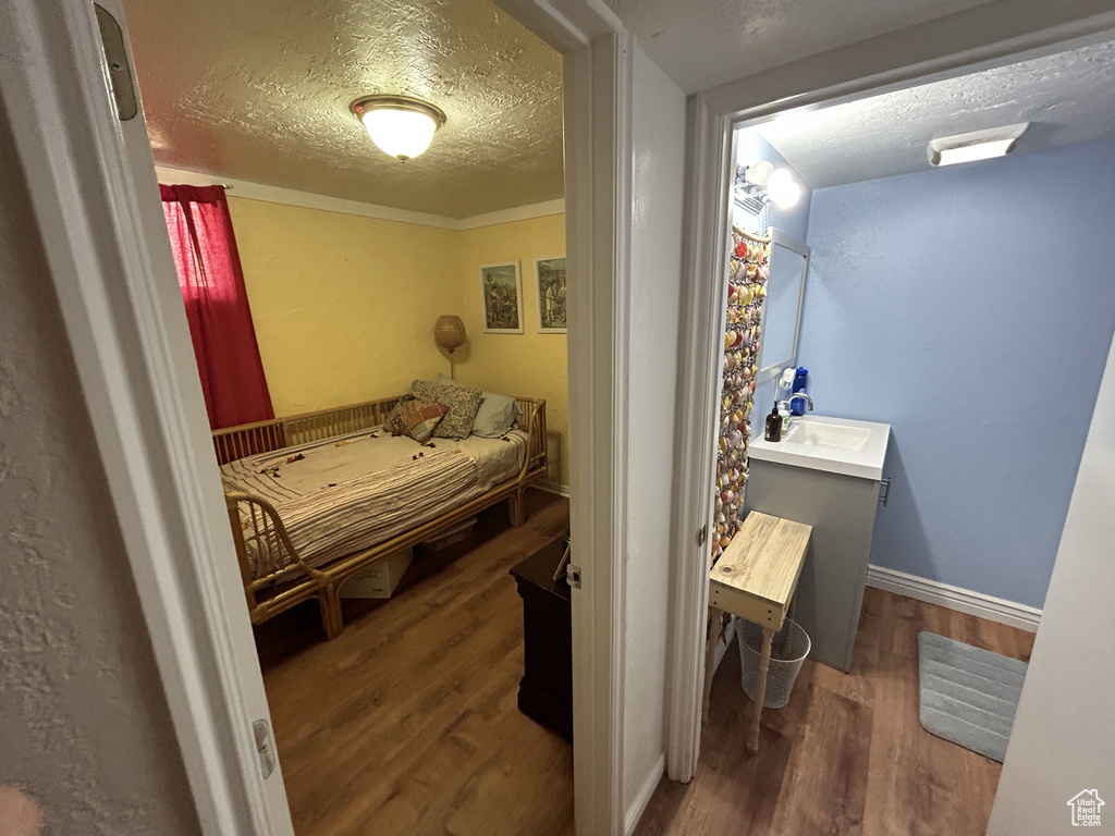 Bedroom featuring wood finished floors and a textured ceiling