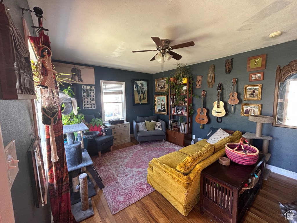 Living area with plenty of natural light, a ceiling fan, and wood finished floors