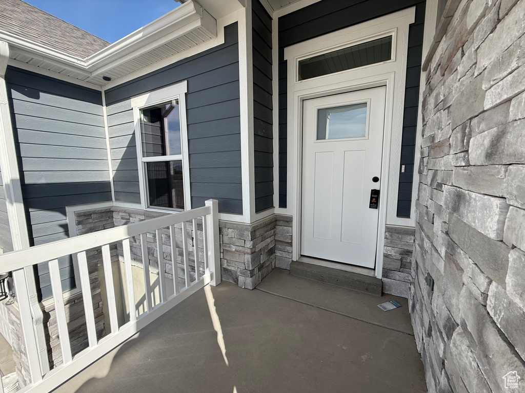 Entrance to property with stone siding and covered porch