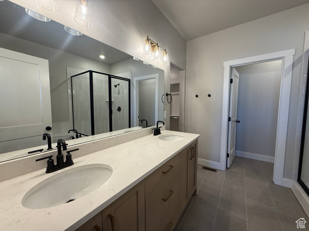 Full bathroom featuring a shower stall, tile patterned flooring, and double vanity
