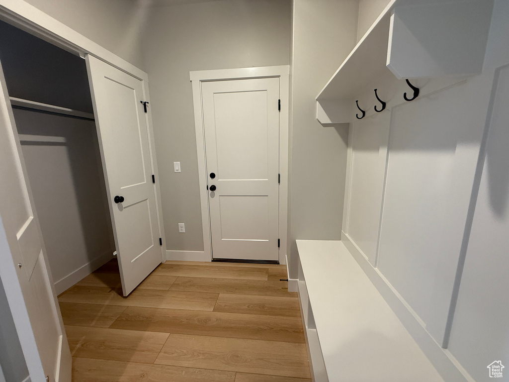 Mudroom with light wood finished floors and baseboards