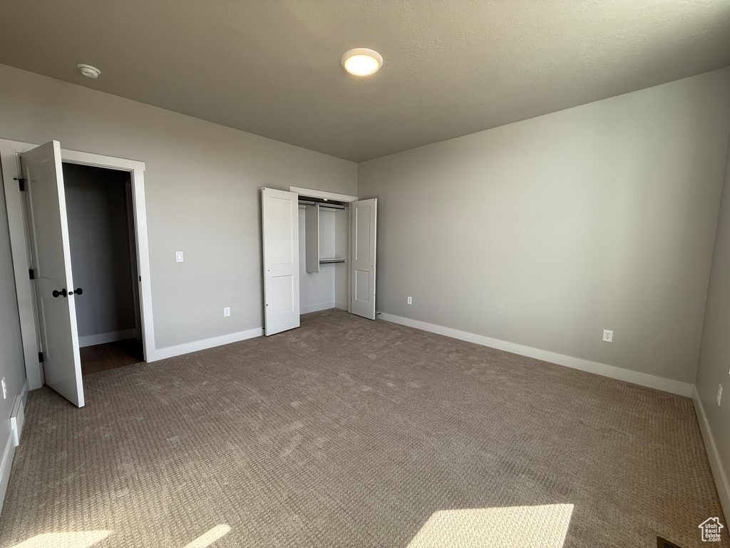 Unfurnished bedroom featuring carpet flooring and a closet