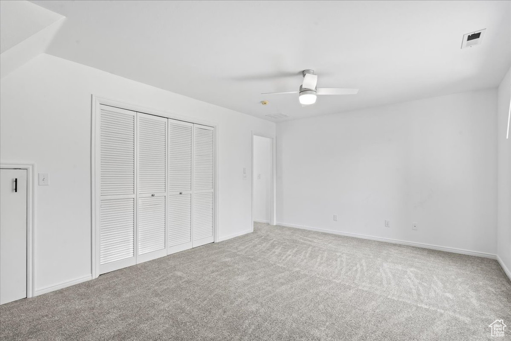 Unfurnished bedroom with carpet floors, a closet, and a ceiling fan