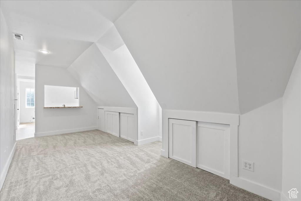 Bonus room with carpet flooring and lofted ceiling