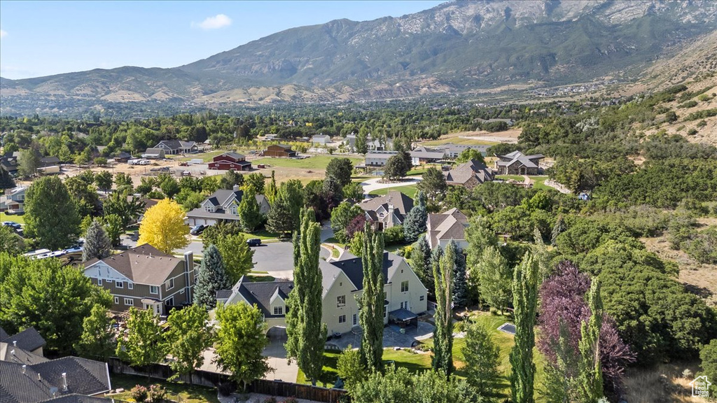 Aerial view of property and surrounding area featuring nearby suburban area and mountains