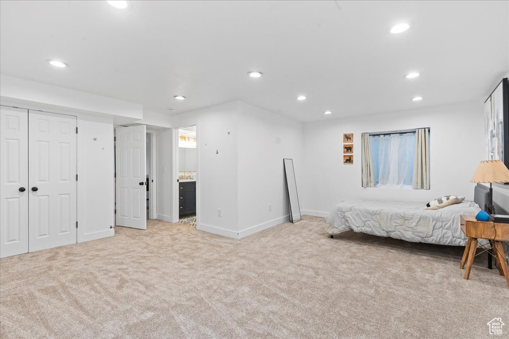 Bedroom featuring light carpet, recessed lighting, and ensuite bath