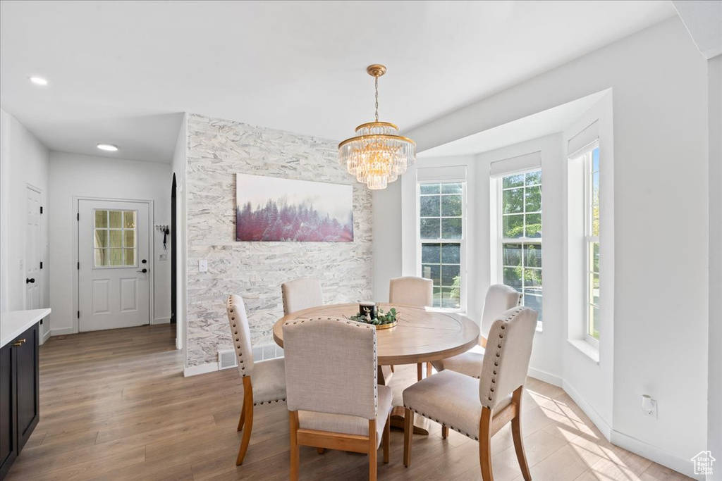 Dining area with a chandelier, light wood-style flooring, and recessed lighting