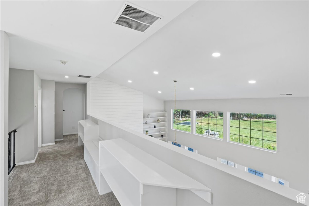 Hallway with carpet flooring, recessed lighting, arched walkways, and lofted ceiling