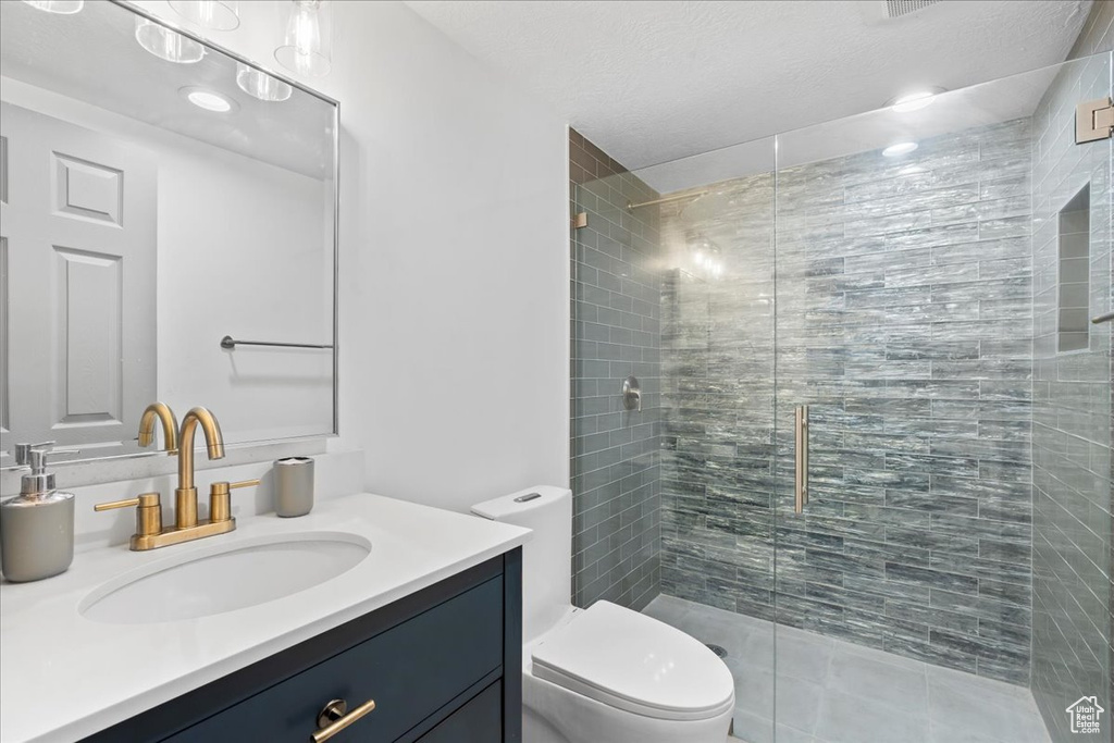 Full bath featuring a stall shower and vanity