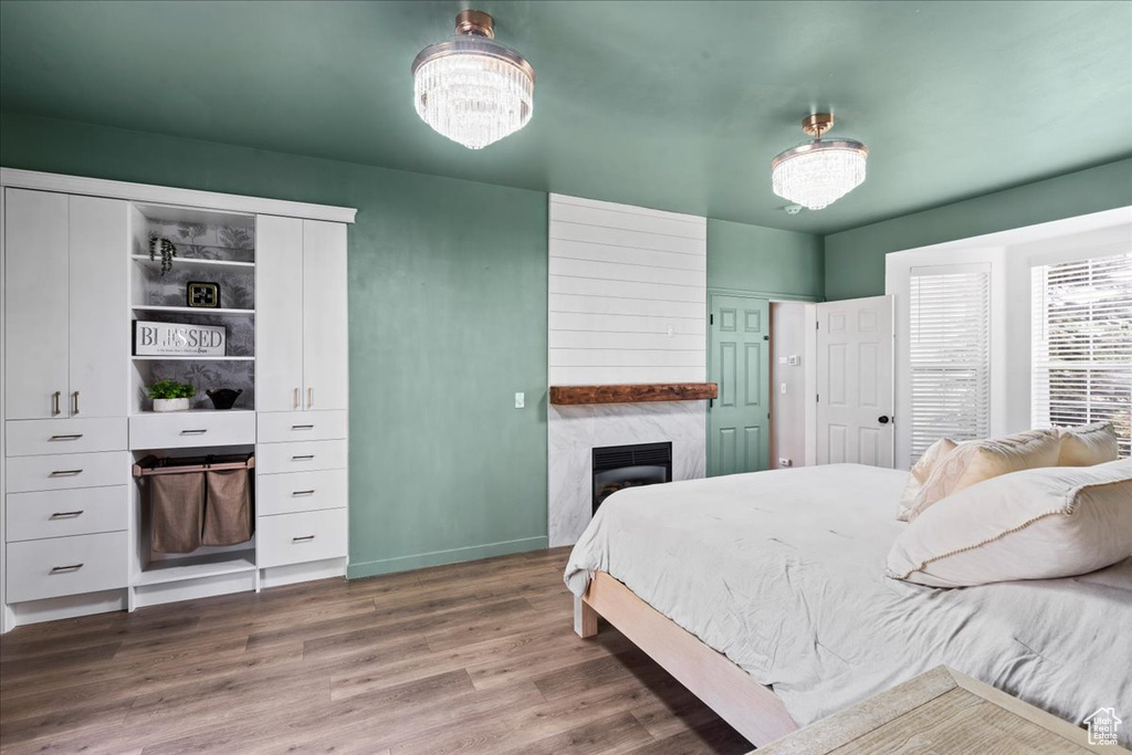 Bedroom with wood finished floors and a high end fireplace