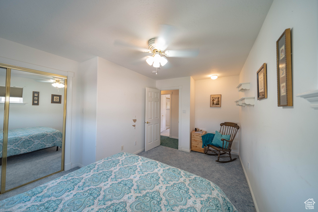 Carpeted bedroom featuring a closet and ceiling fan
