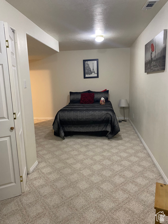 Bedroom featuring light colored carpet