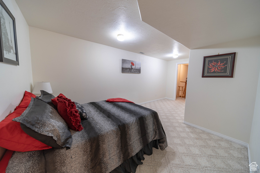 Bedroom featuring light colored carpet and baseboards