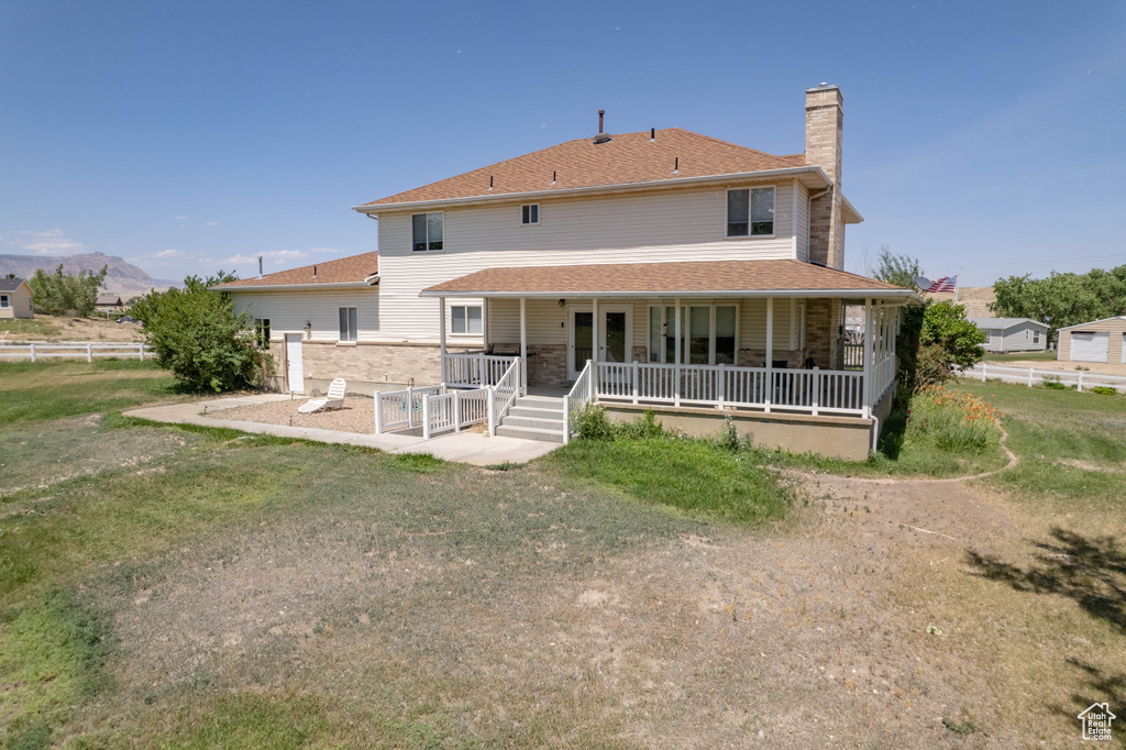 Rear view of property with a chimney and a porch