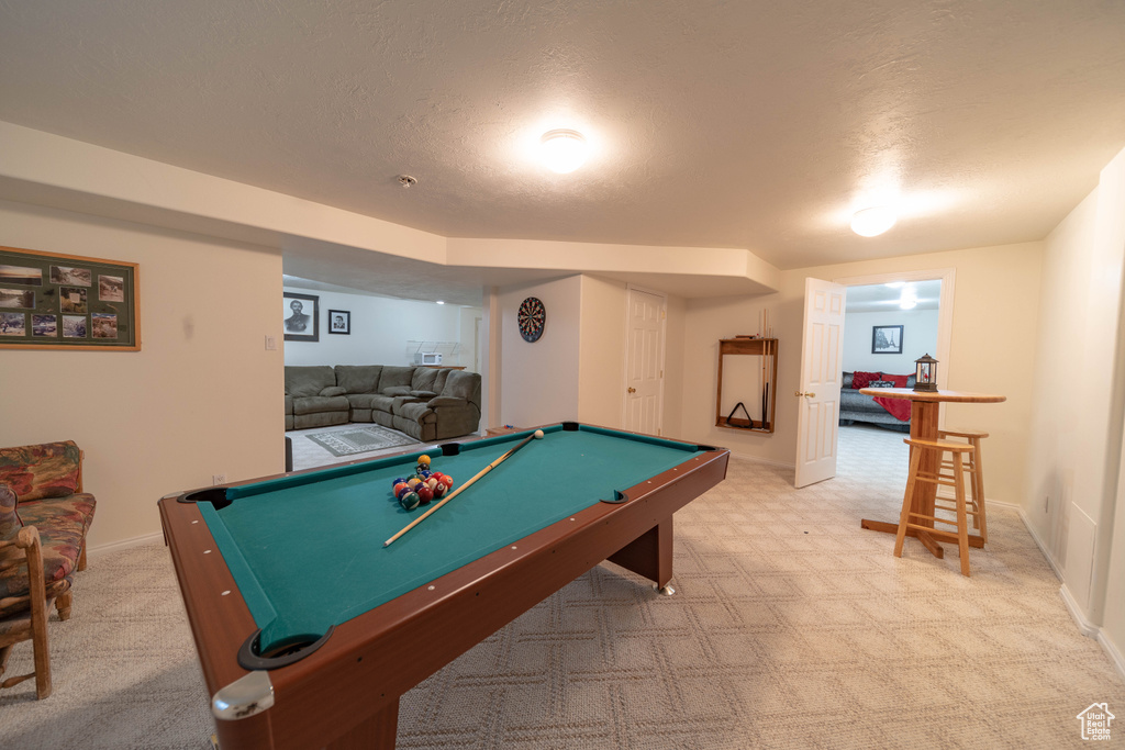 Recreation room with light carpet, billiards table, and a textured ceiling