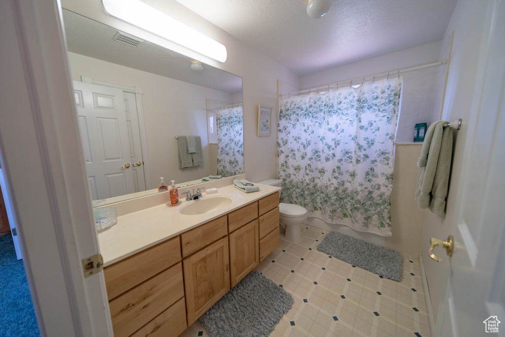 Full bath featuring vanity, shower / bath combination with curtain, and tile patterned flooring