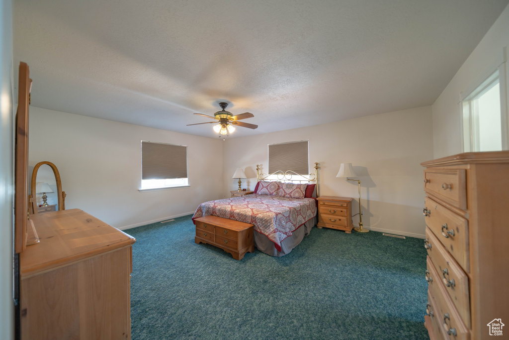 Bedroom featuring dark carpet, a ceiling fan, and a textured ceiling