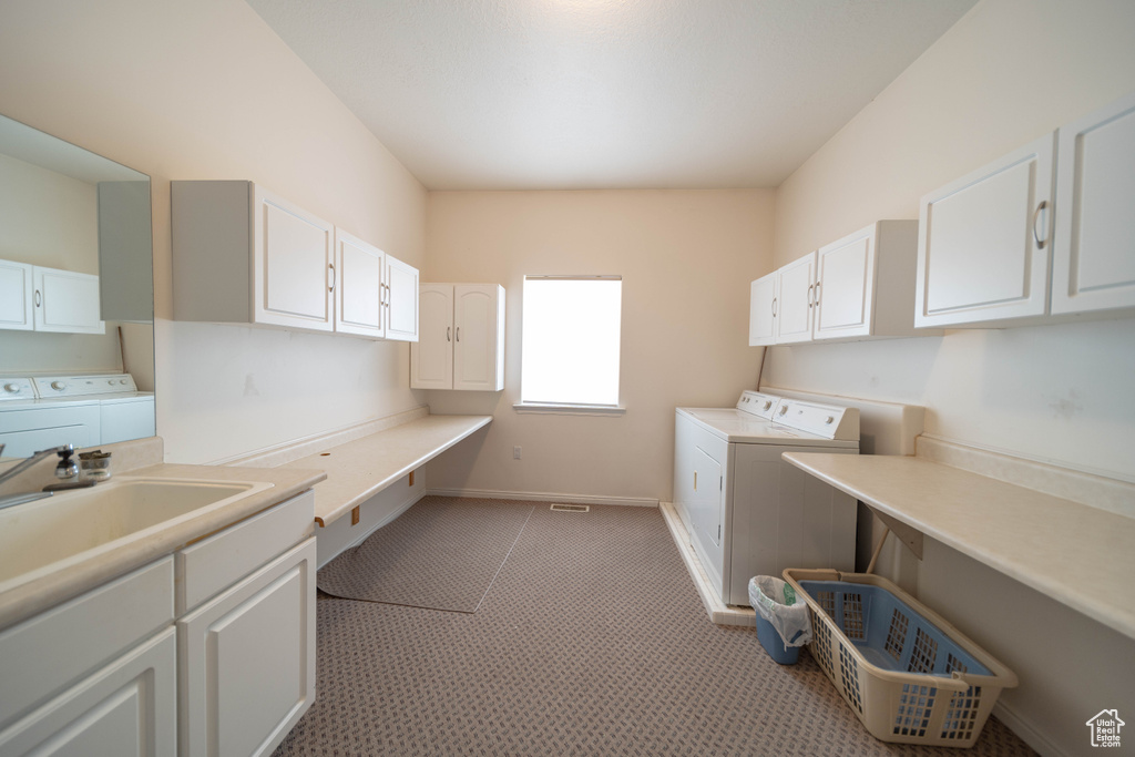 Laundry room featuring washer and dryer, cabinet space, and light colored carpet