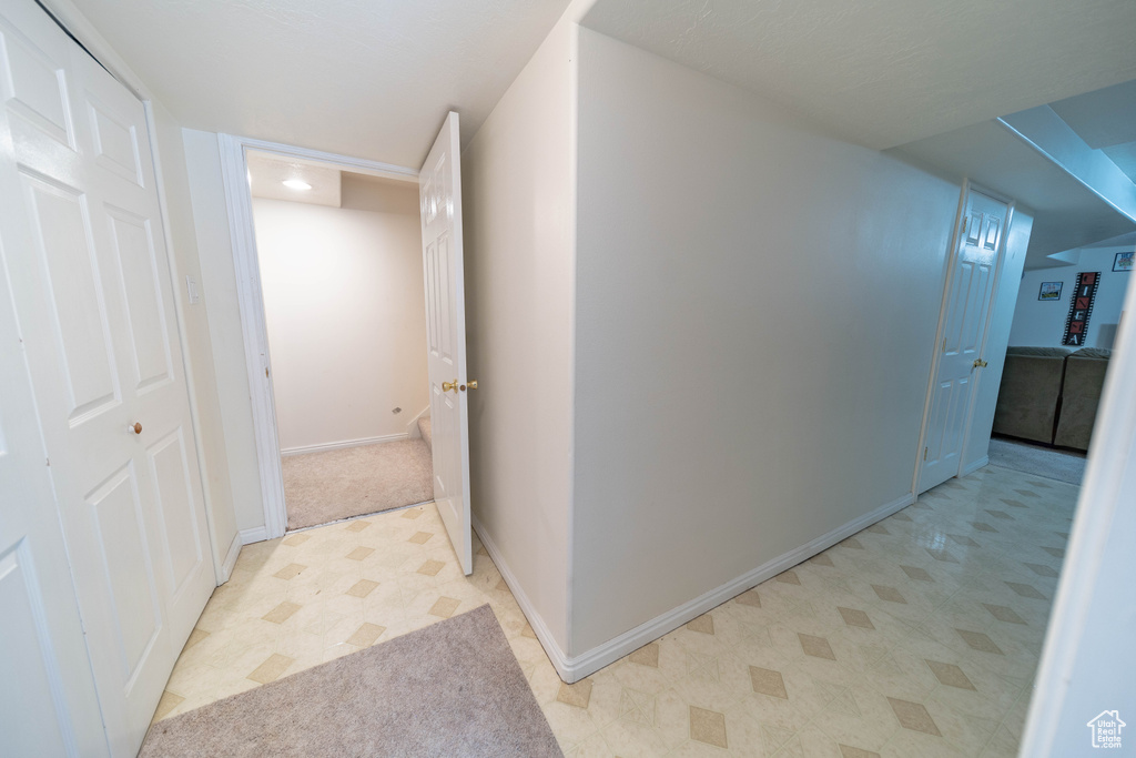Corridor featuring light flooring and baseboards