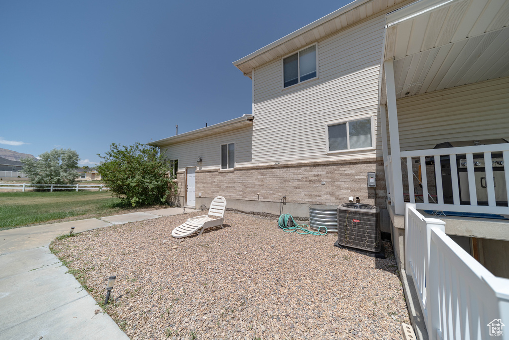 View of side of home featuring brick siding and a cooling unit