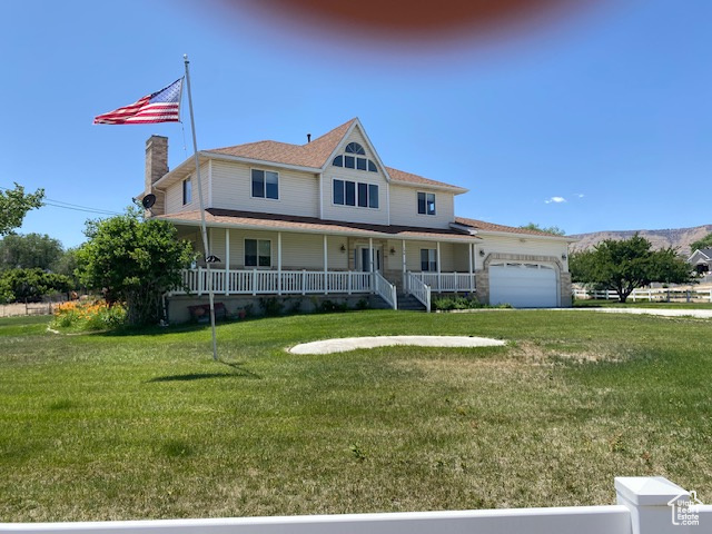 Country-style home with covered porch, an attached garage, and a front lawn