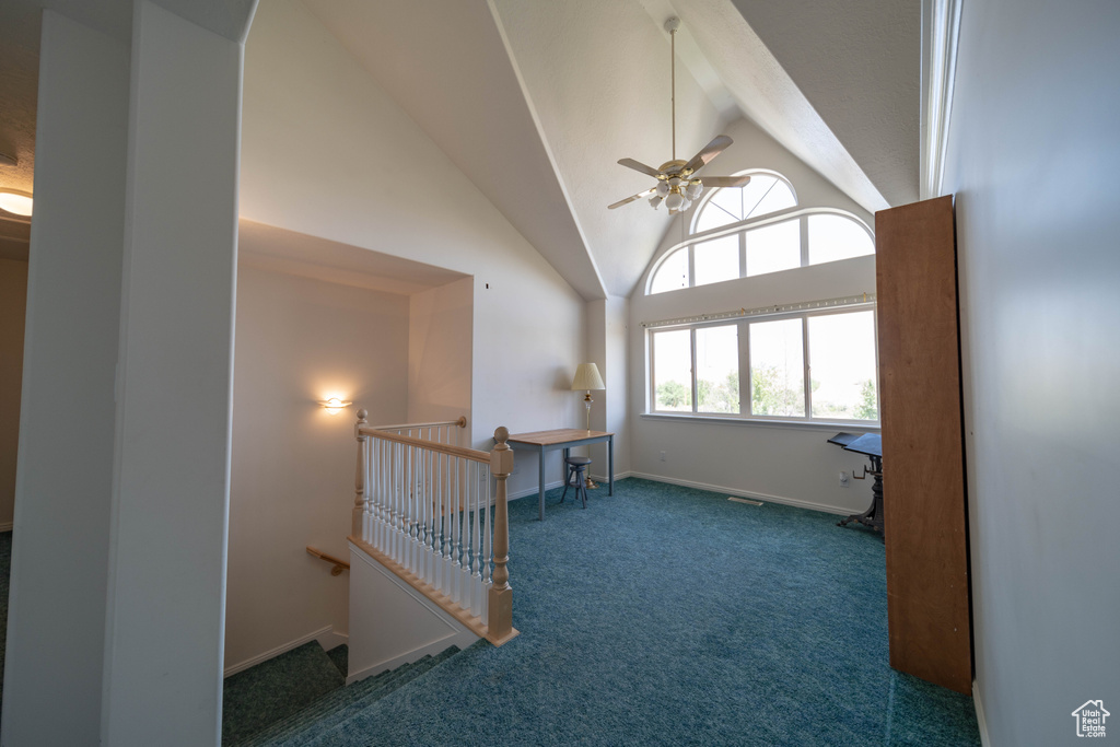 Empty room featuring carpet floors, ceiling fan, high vaulted ceiling, and beam ceiling