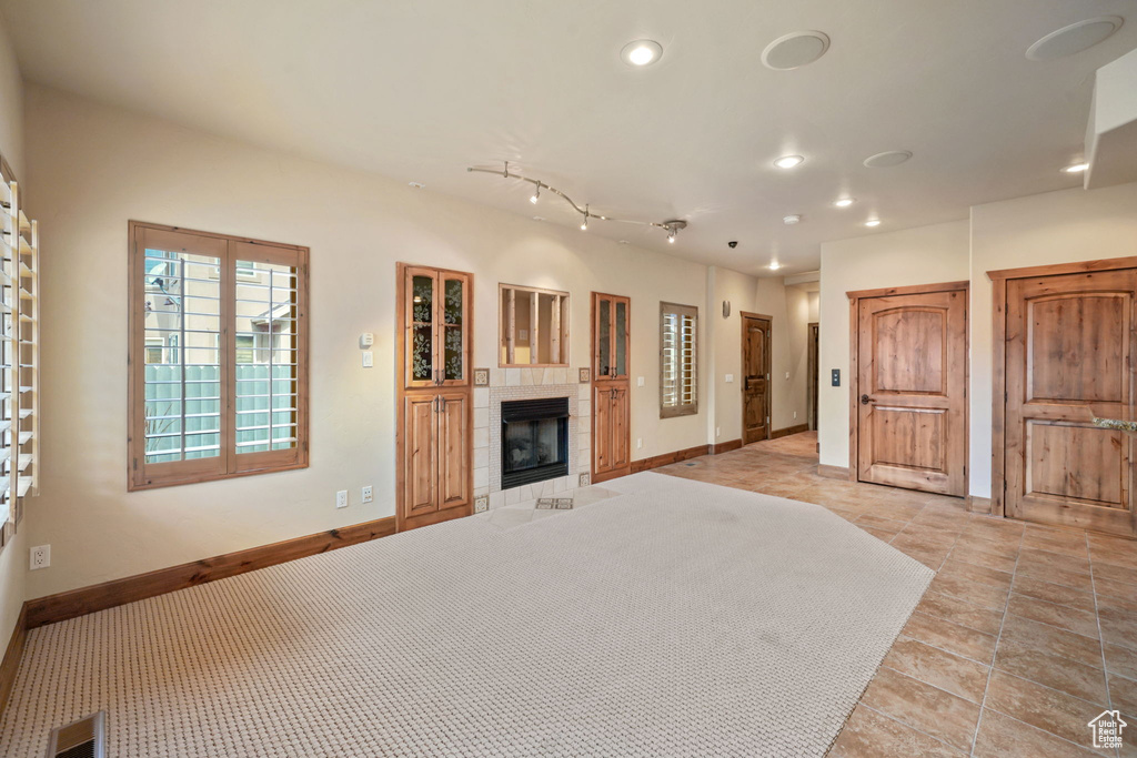 Unfurnished living room with recessed lighting, a fireplace, and light tile patterned flooring