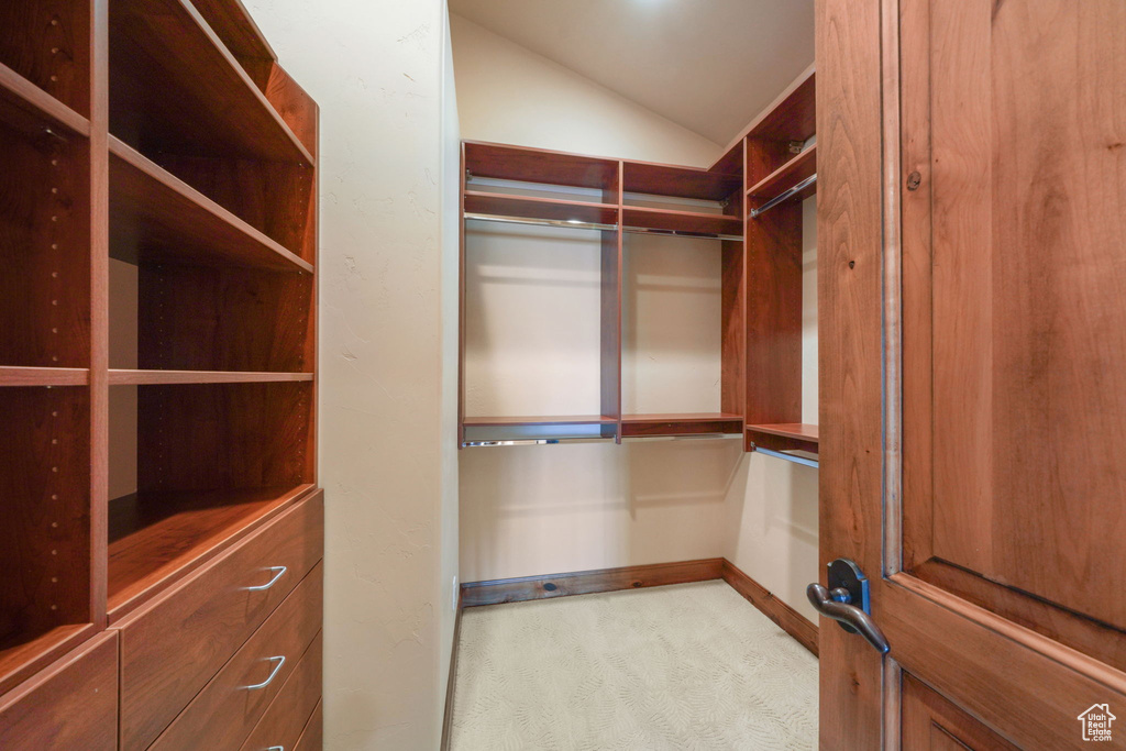 Spacious closet with lofted ceiling and carpet flooring