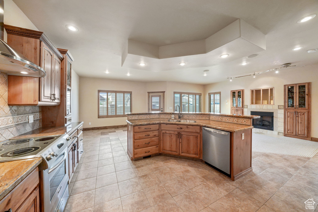 Kitchen featuring stainless steel appliances, custom range hood, open floor plan, recessed lighting, and healthy amount of natural light