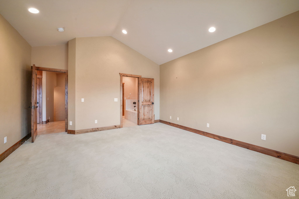Unfurnished bedroom with light colored carpet, lofted ceiling, and recessed lighting