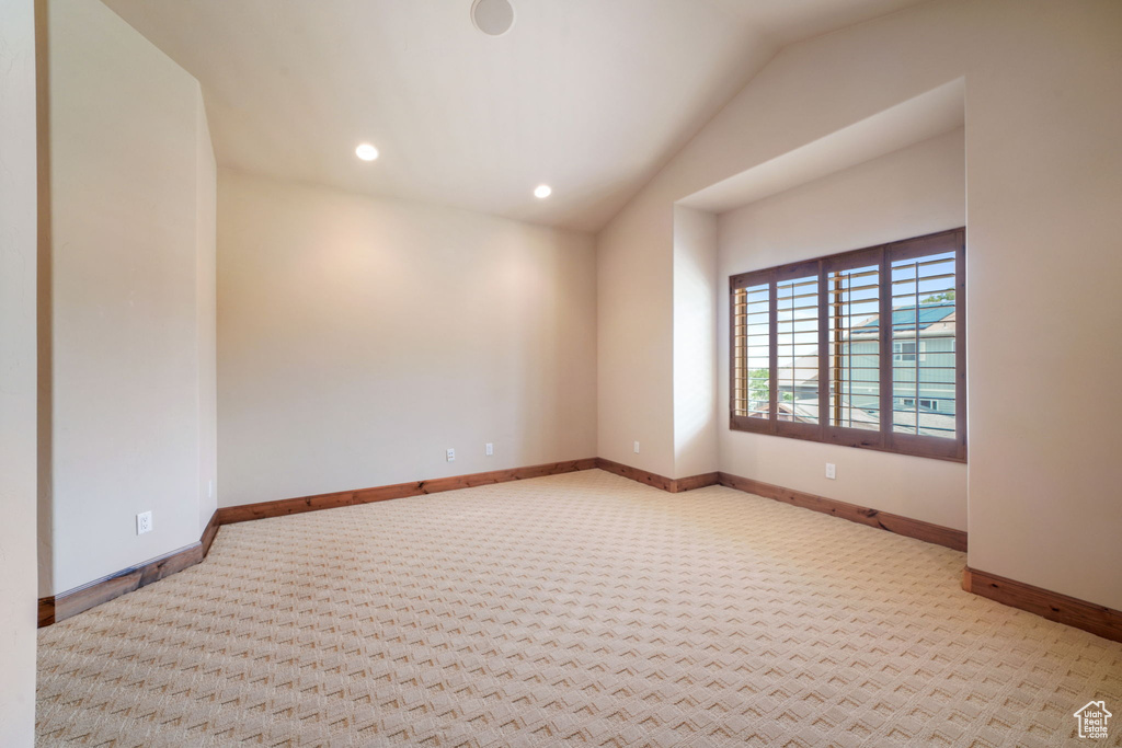 Empty room featuring lofted ceiling, carpet flooring, and recessed lighting