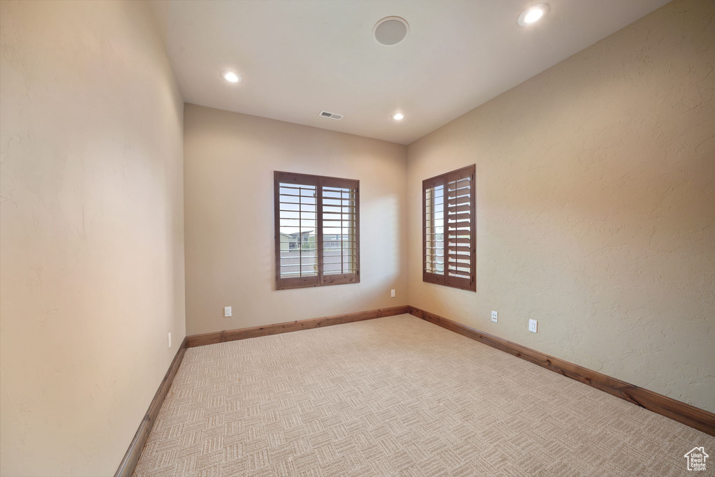 Empty room featuring light colored carpet and recessed lighting