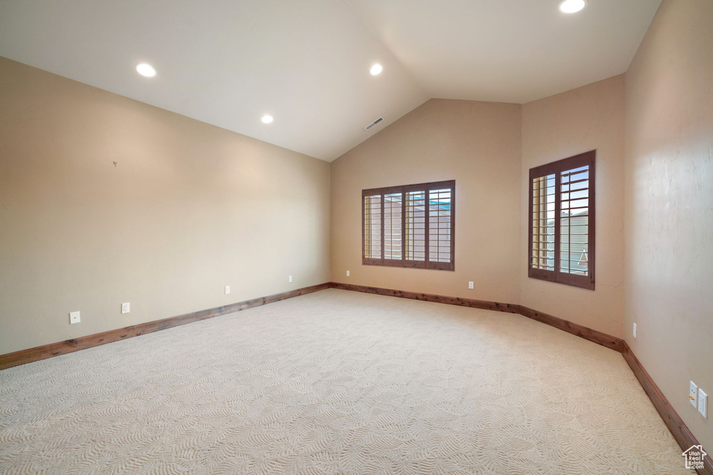 Spare room with light colored carpet, vaulted ceiling, and recessed lighting