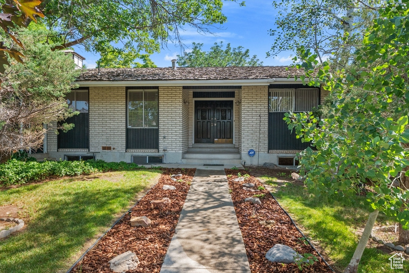 View of front of house featuring brick siding, entry steps, and a front yard