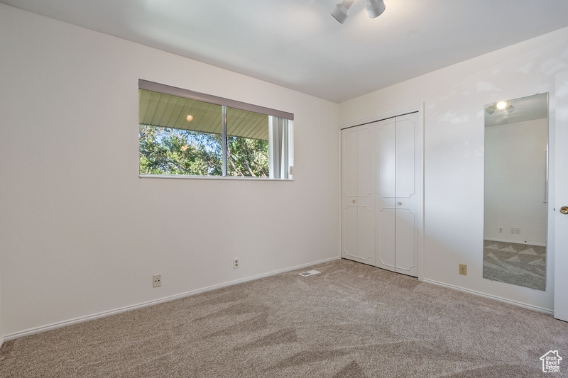 Unfurnished bedroom featuring carpet and a closet