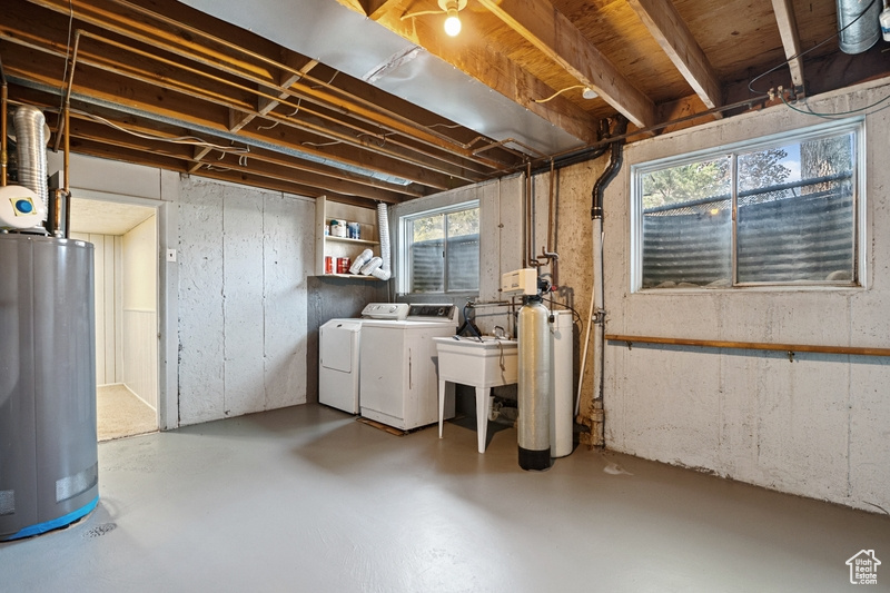 Below grade area with water heater, washing machine and dryer, and a water softener