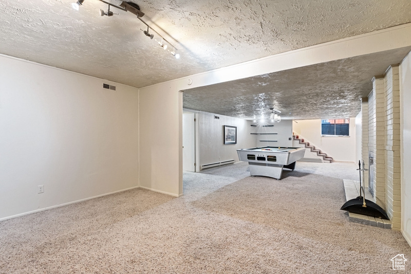 Game room featuring a textured ceiling, carpet floors, a baseboard heating unit, and pool table