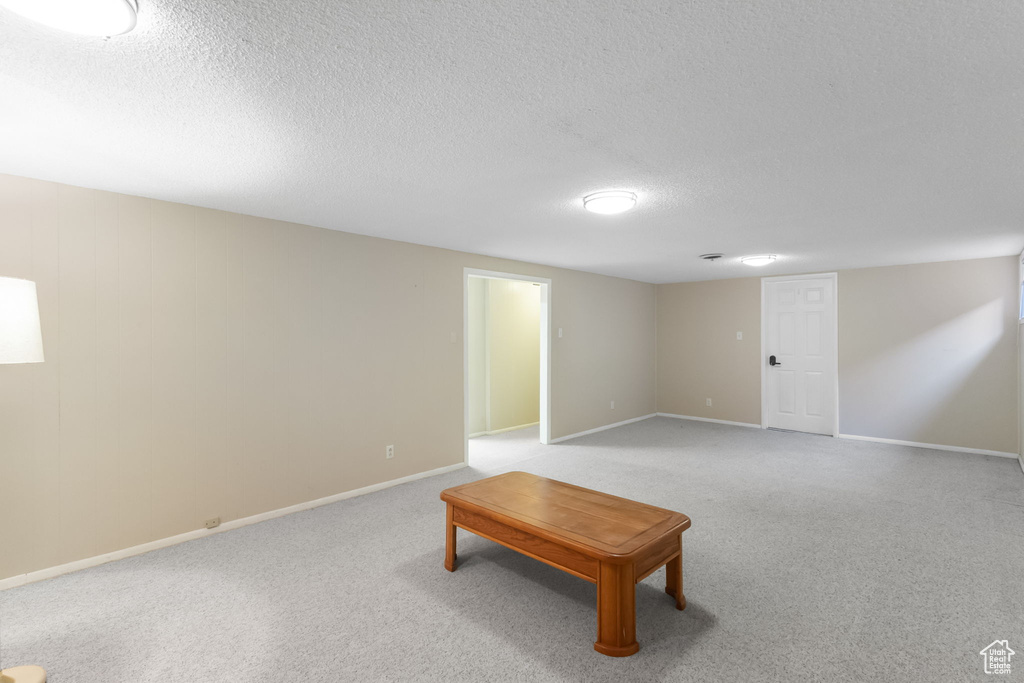 Finished below grade area featuring a textured ceiling and carpet