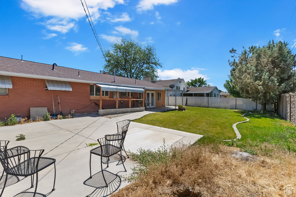 Back of property featuring a patio area, a fenced backyard, brick siding, and a chimney