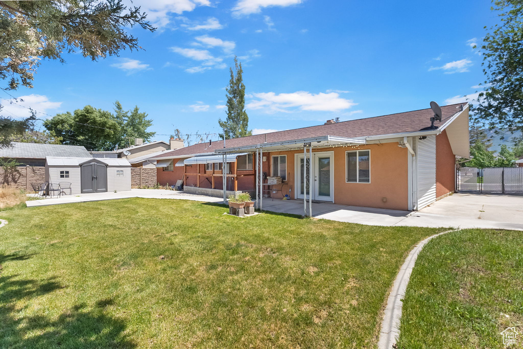 Rear view of property with a patio, a storage shed, french doors, and stucco siding