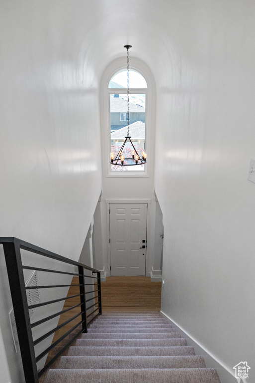 Stairway featuring a chandelier and carpet floors