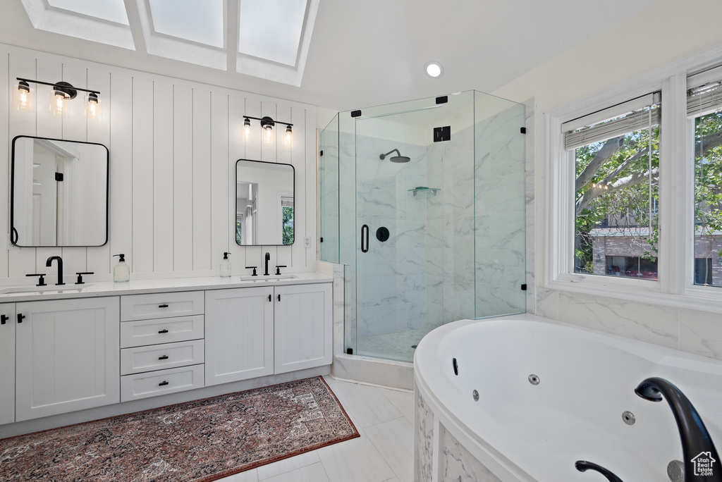 Bathroom with a marble finish shower, a tub with jets, and double vanity