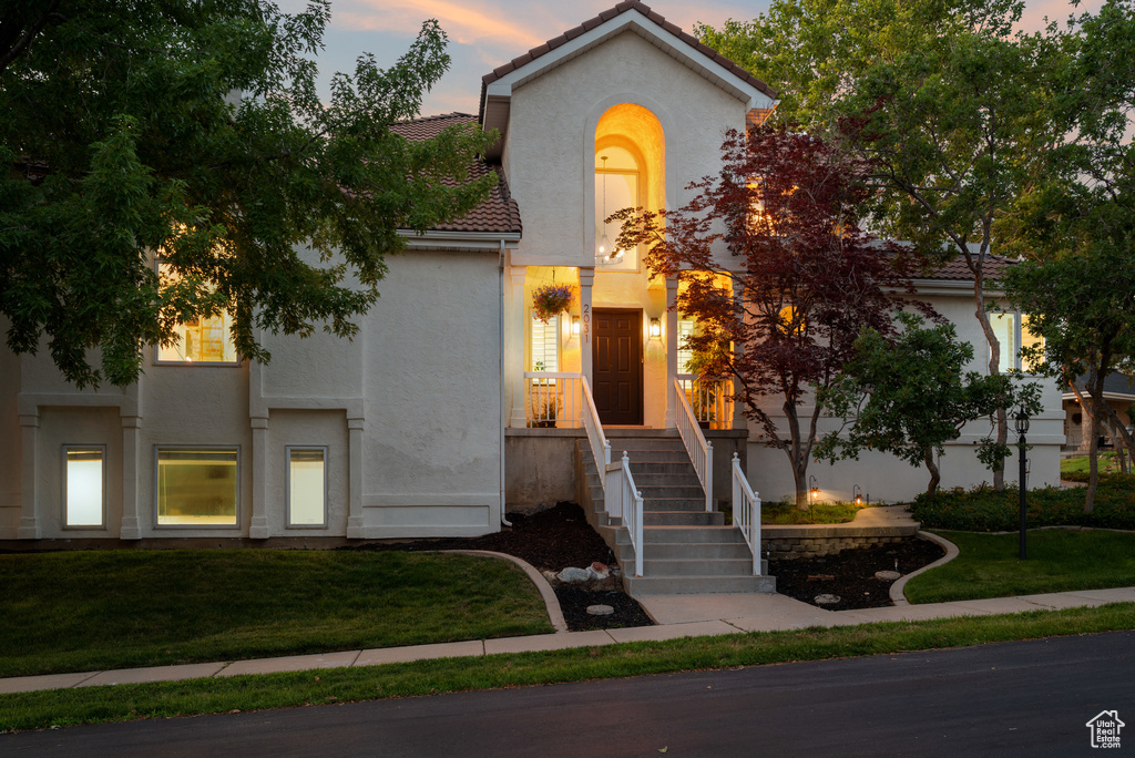 Mediterranean / spanish-style home featuring stucco siding, a tiled roof, and a lawn