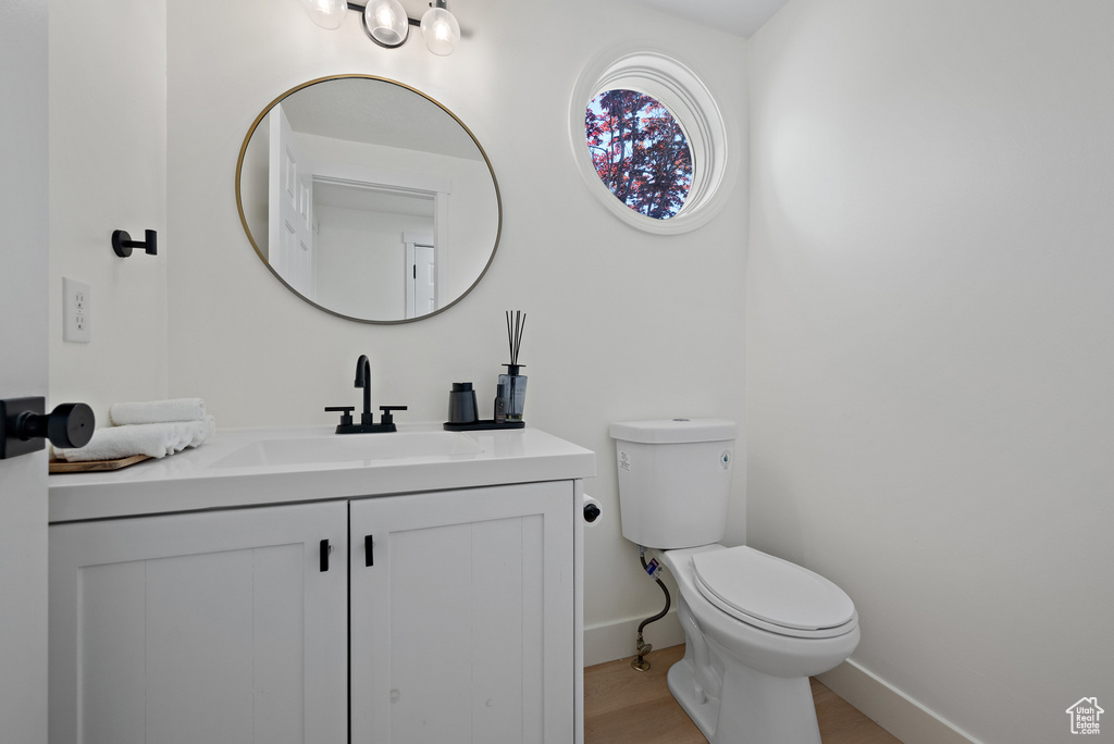 Half bathroom featuring vanity and wood finished floors