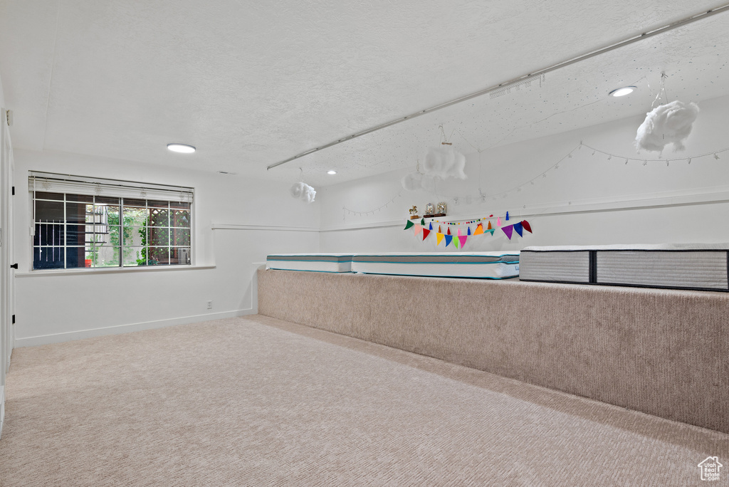 Interior space featuring a textured ceiling, recessed lighting, and carpet flooring