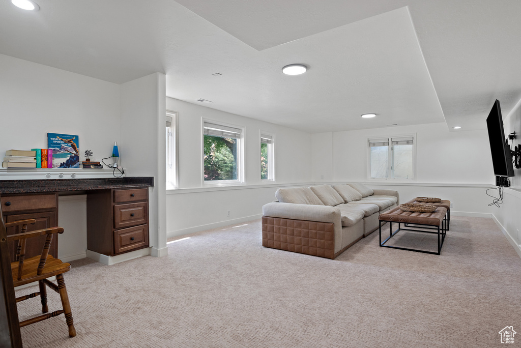 Living room featuring light carpet, recessed lighting, and a desk